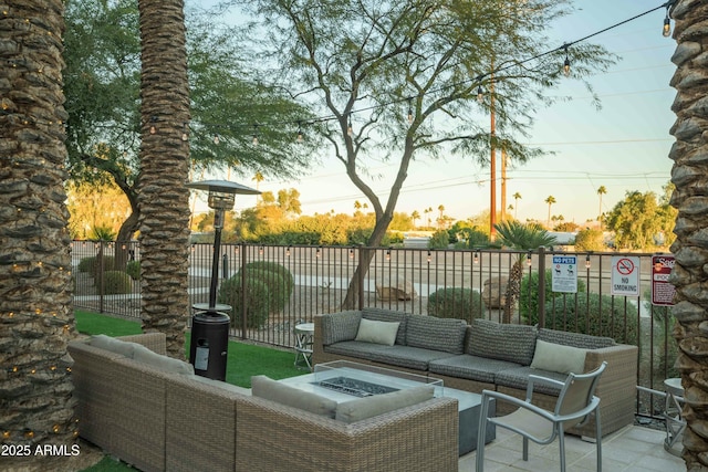 view of patio featuring an outdoor living space with a fire pit and fence