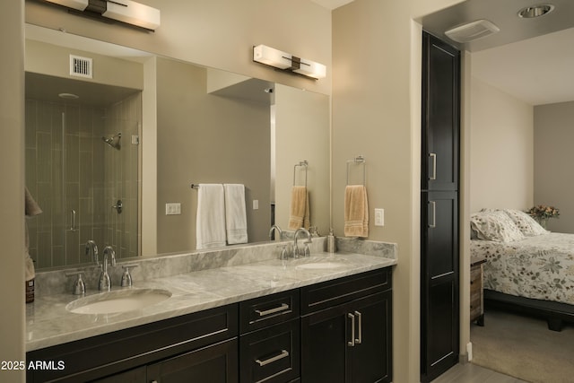 ensuite bathroom with double vanity, ensuite bath, visible vents, and a sink