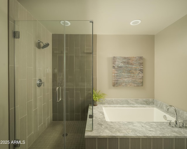 bathroom with a stall shower and a garden tub