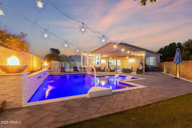 4446 W Kimberly Way, Glendale, AZ 85308 - pool at dusk with a patio area, an outdoor living space with a fire pit, a fenced backyard, and a jacuzzi