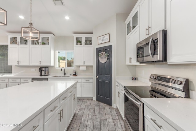 4446 W Kimberly Way, Glendale, AZ 85308 - kitchen featuring appliances with stainless steel finishes, light wood-style flooring, light countertops, white cabinets, and recessed lighting
