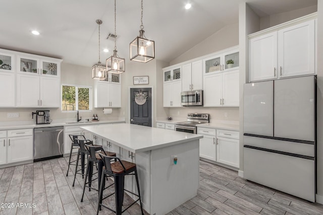 4446 W Kimberly Way, Glendale, AZ 85308 - kitchen with appliances with stainless steel finishes, a sink, a center island, vaulted ceiling, and light countertops