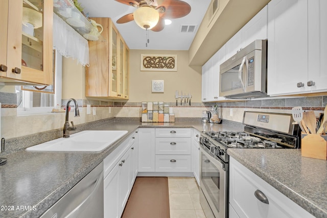 kitchen with appliances with stainless steel finishes, tasteful backsplash, white cabinetry, and sink