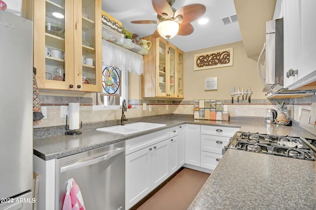 kitchen with white cabinets, backsplash, sink, and stainless steel appliances