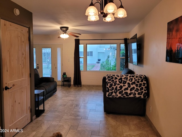 living room with ceiling fan with notable chandelier