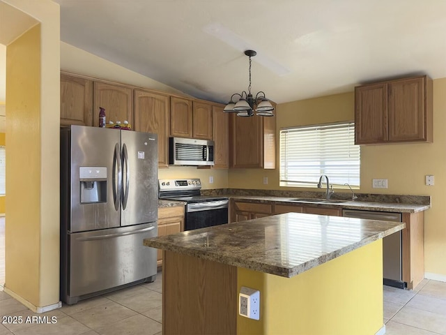 kitchen with light tile patterned flooring, sink, hanging light fixtures, a kitchen island, and stainless steel appliances