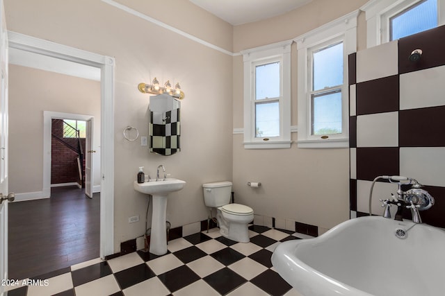 bathroom featuring sink, toilet, tile patterned floors, and a washtub