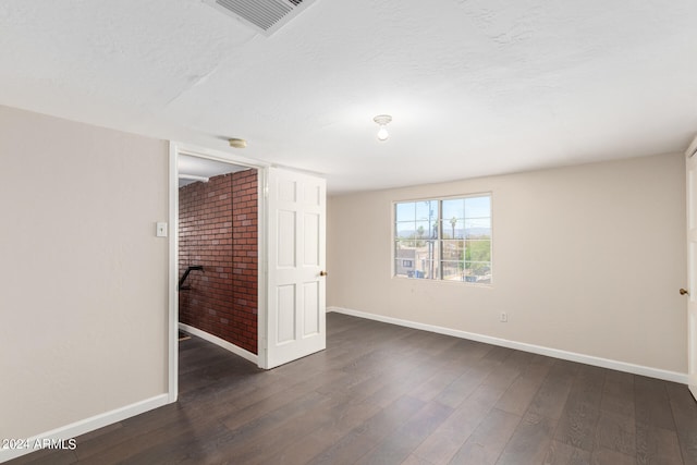 unfurnished room with dark wood-type flooring