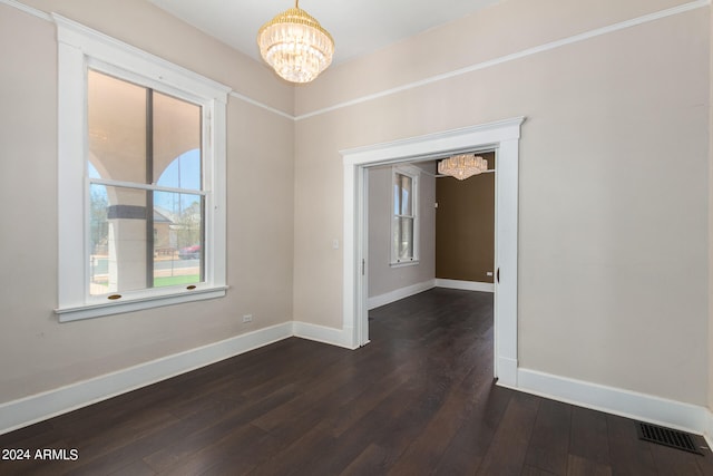 empty room featuring dark hardwood / wood-style flooring and a chandelier