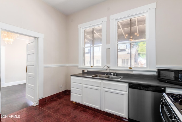 kitchen with dark tile patterned floors, dishwasher, a healthy amount of sunlight, and sink