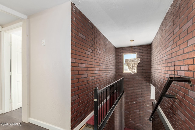 interior space featuring brick wall and an inviting chandelier