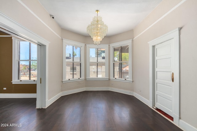 unfurnished room with a chandelier and dark hardwood / wood-style flooring