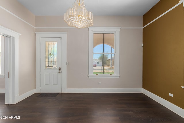 foyer entrance featuring an inviting chandelier, a wealth of natural light, and dark wood-type flooring