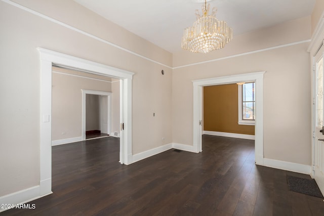 empty room with an inviting chandelier and dark wood-type flooring