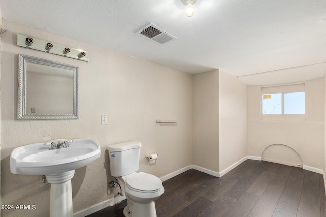 bathroom with toilet and hardwood / wood-style flooring