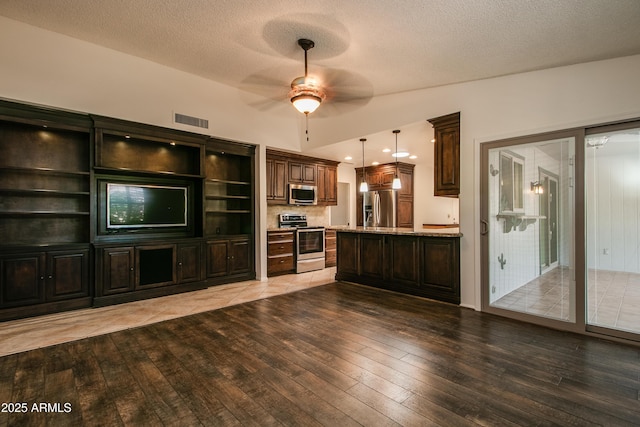 interior space featuring lofted ceiling, a textured ceiling, visible vents, light wood finished floors, and a ceiling fan