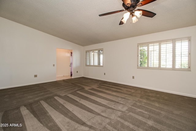 spare room with lofted ceiling, a textured ceiling, dark carpet, ceiling fan, and baseboards