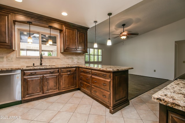 kitchen featuring light stone counters, stainless steel dishwasher, a sink, ceiling fan, and backsplash