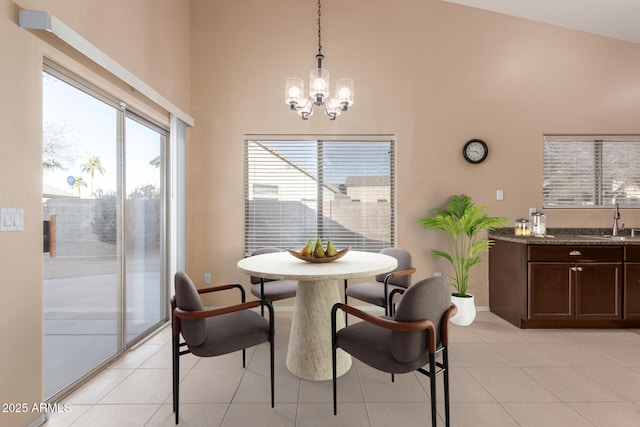 tiled dining space with a notable chandelier, a healthy amount of sunlight, and a high ceiling