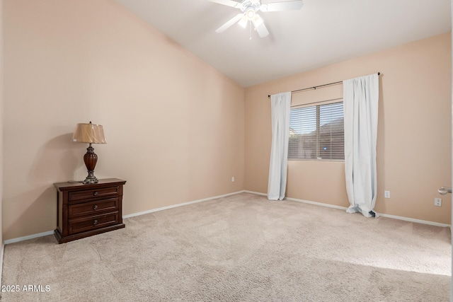 empty room with lofted ceiling, light colored carpet, and ceiling fan