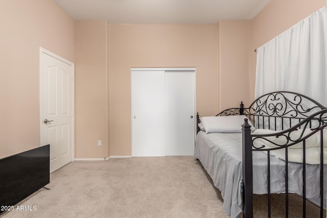 bedroom with light carpet and a closet