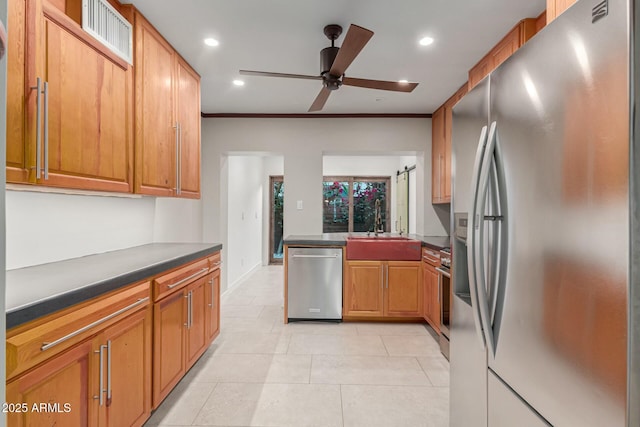 kitchen featuring appliances with stainless steel finishes, ceiling fan, sink, light tile patterned floors, and a barn door