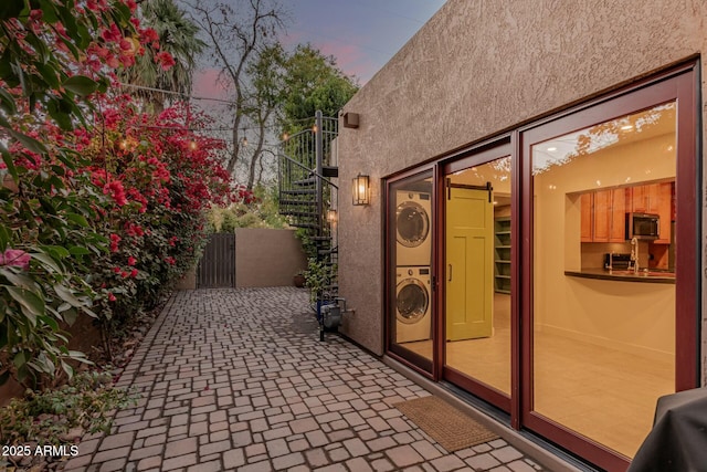 patio terrace at dusk with stacked washer and clothes dryer