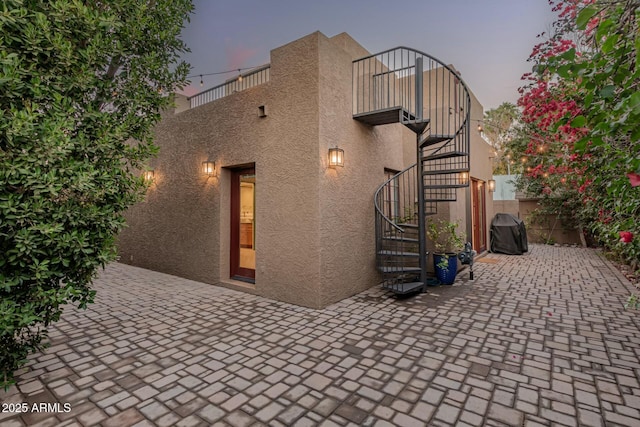 property exterior at dusk with a patio area