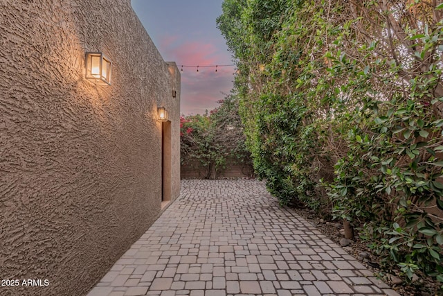 property exterior at dusk featuring a patio area