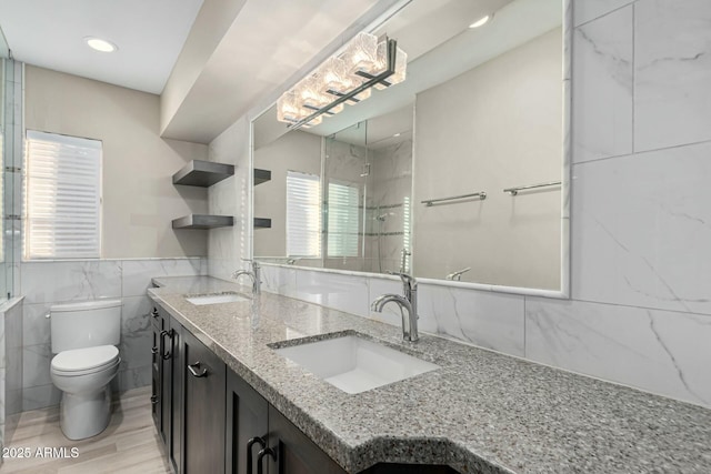 bathroom featuring vanity, toilet, tile walls, tiled shower, and wood-type flooring