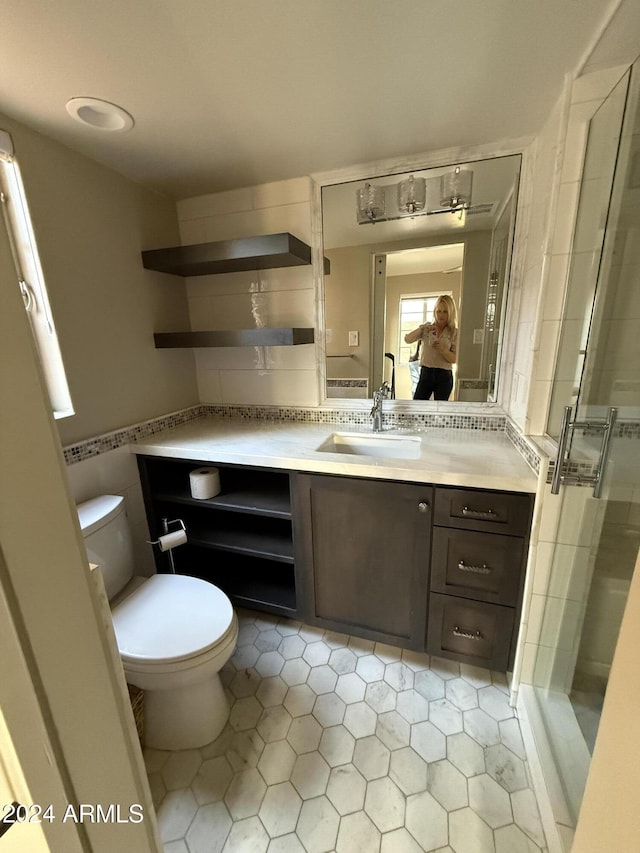 bathroom with vanity, tile patterned flooring, toilet, tile walls, and an enclosed shower