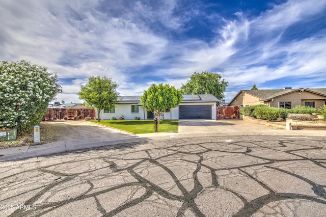 4162 W Sierra St, Phoenix, AZ 85029 - obstructed view of property with driveway, solar panels, and an attached garage
