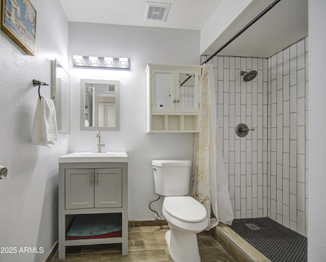 4162 W Sierra St, Phoenix, AZ 85029 - bathroom with vanity, toilet, tiled shower, wood finished floors, and baseboards