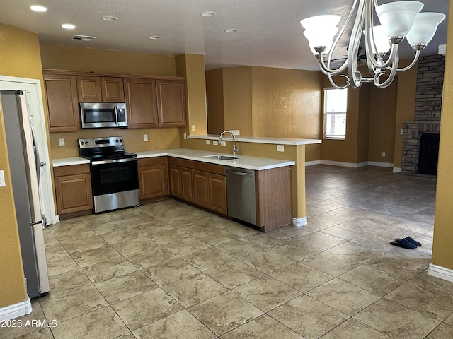 7511 S 45th Dr, Laveen, AZ 85339 - kitchen featuring an inviting chandelier, a peninsula, a sink, light countertops, and appliances with stainless steel finishes