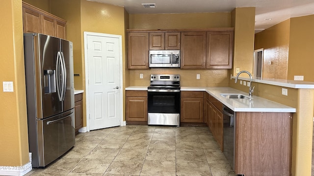 7511 S 45th Dr, Laveen, AZ 85339 - kitchen with visible vents, a sink, appliances with stainless steel finishes, brown cabinetry, and light countertops