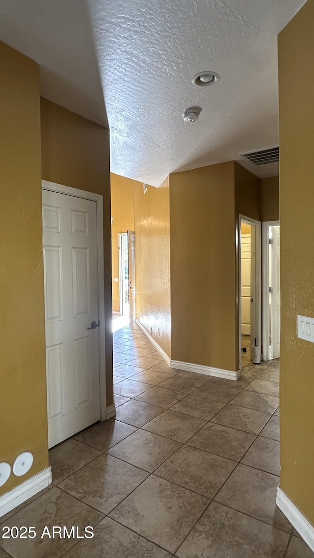 7511 S 45th Dr, Laveen, AZ 85339 - hall featuring tile patterned flooring, visible vents, a textured ceiling, and baseboards