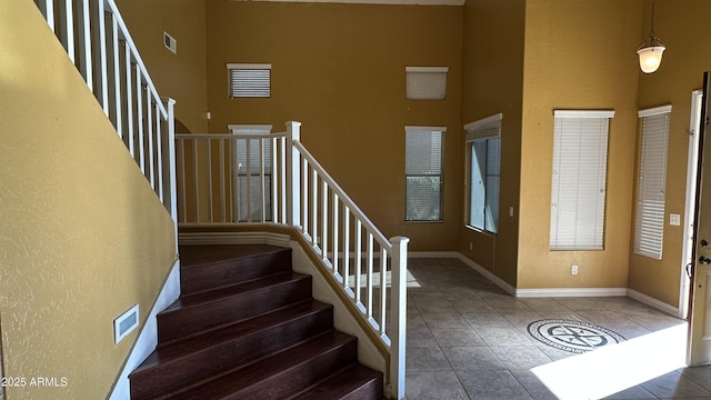 7511 S 45th Dr, Laveen, AZ 85339 - stairs with tile patterned floors, visible vents, baseboards, and a towering ceiling