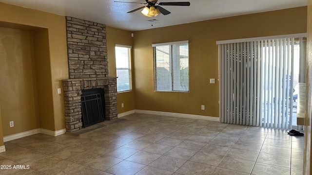 7511 S 45th Dr, Laveen, AZ 85339 - unfurnished living room featuring visible vents, baseboards, light tile patterned floors, a stone fireplace, and a ceiling fan