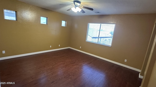 7511 S 45th Dr, Laveen, AZ 85339 - unfurnished room with visible vents, baseboards, dark wood-type flooring, and a ceiling fan