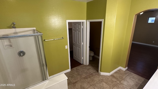 7511 S 45th Dr, Laveen, AZ 85339 - bathroom featuring tile patterned flooring, toilet, baseboards, and a stall shower