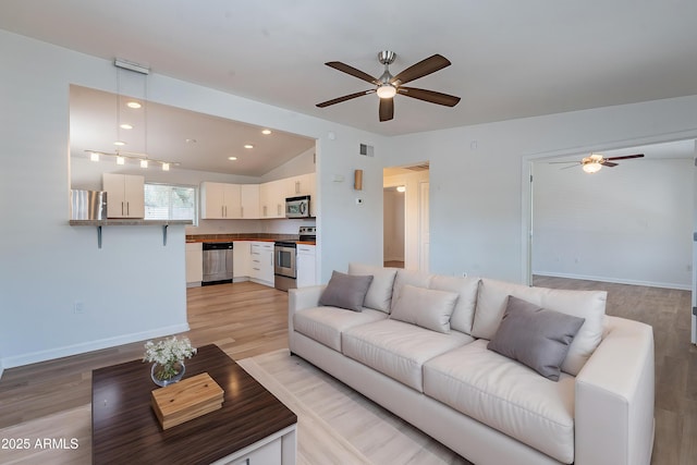 1219 E Colter St Unit 8, Phoenix, AZ 85014 - living room with ceiling fan, light wood-style floors, vaulted ceiling, baseboards, and recessed lighting