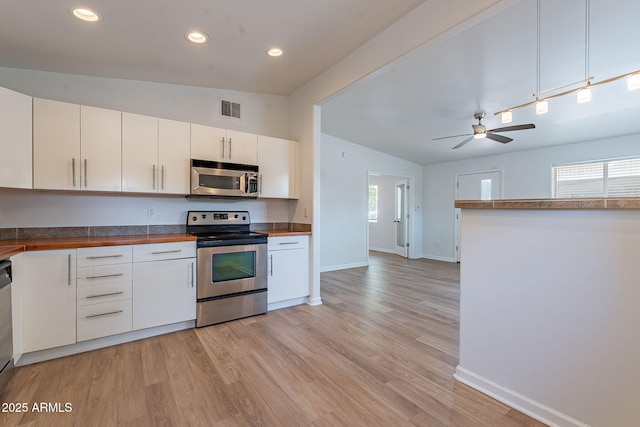 1219 E Colter St Unit 8, Phoenix, AZ 85014 - kitchen featuring stainless steel appliances, lofted ceiling, baseboards, light wood-style flooring, and white cabinetry