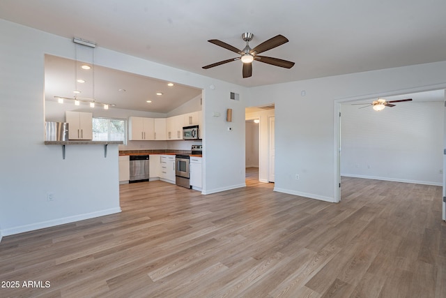 1219 E Colter St Unit 8, Phoenix, AZ 85014 - unfurnished living room featuring a ceiling fan, light wood-type flooring, vaulted ceiling, baseboards, and recessed lighting