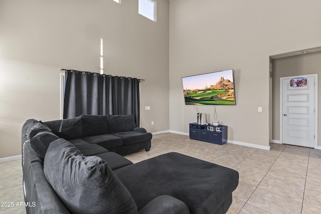 living room with light tile patterned floors, a high ceiling, and baseboards