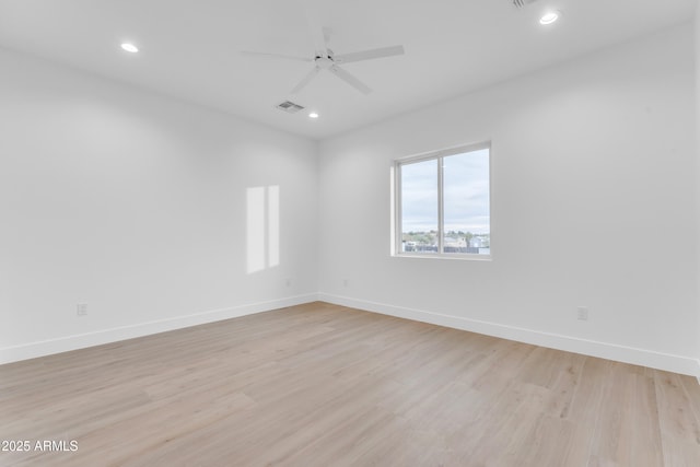 empty room with ceiling fan and light hardwood / wood-style floors