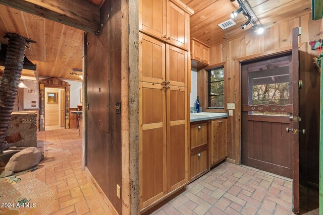 interior space featuring track lighting, wooden walls, and wood ceiling