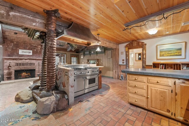 kitchen with pendant lighting, light brown cabinets, double oven range, wooden ceiling, and wood walls