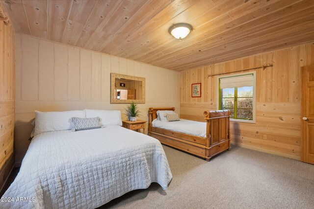 carpeted bedroom featuring wood ceiling and wooden walls