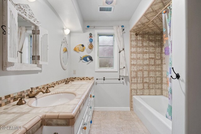 bathroom featuring tile patterned flooring, shower / bath combo, vanity, and tasteful backsplash