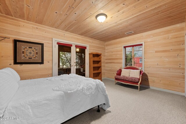 bedroom with access to outside, carpet flooring, wooden ceiling, and french doors